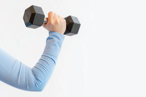 istock Female hand holding an iron dumbbell on white background, copy space. 1468401452