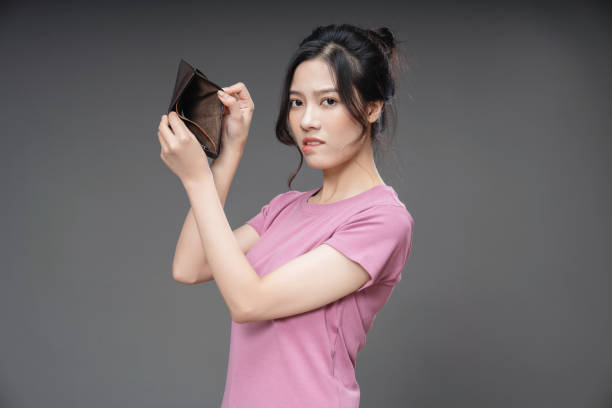 istock Young Asian woman holding empty wallet on background 1468406403