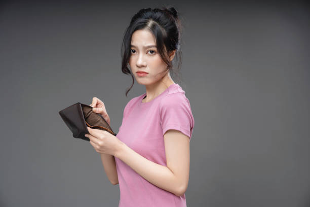 istock Young Asian woman holding empty wallet on background 1468406424