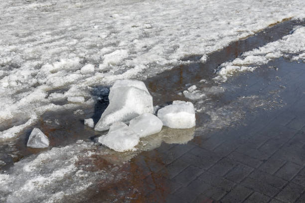 istock Melting snow and a puddle on the paved sidewalk 1468407166