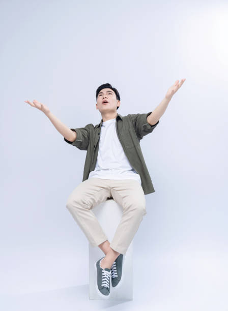 istock Young Asian man sitting on background 1468408251