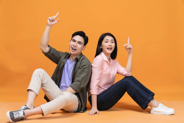 istock Young Asian couple sitting on background 1468408719