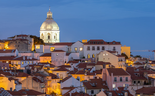 A twilight image of the famous 'Miradouro de Santa Luzia' over the bay. In the image is the is a close-up view of the National Pantheon Church.