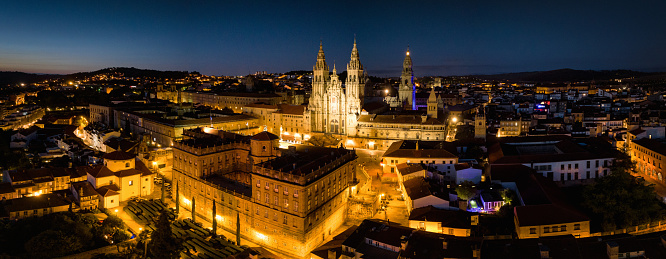 Santiago de Compostela Night Sunset XXL Panorama. Illuminated City of Santiago de Compostela with the famous Santiago de Compostela Cathedral at Night after Sunset. Aerial Drone View XXL Stiched Panorama overlooking the Urban Cityscape. Santiago de Compostela, A Coruña Province, Galicia, Spain, Europe