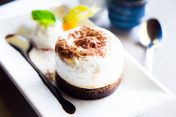 Homemade tiramisu. Traditional Italian dessert in a glass on a wooden board and a dark wooden background. From above