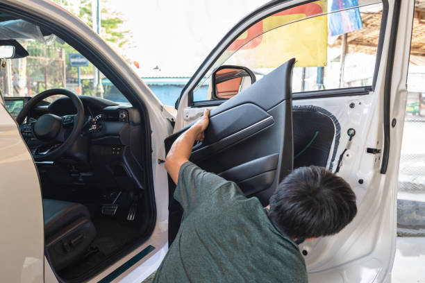 Mechanic man unpacking and assemble vehicle door part for checking car problem or installing speaker in workshop Mechanic man unpacking and assemble vehicle door part for checking car problem or installing speaker in garage workshop car door panels stock pictures, royalty-free photos & images