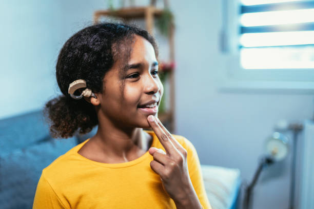 hearing aid in young girl's ear. teenager girl wearing a hearing aid. - american sign language imagens e fotografias de stock