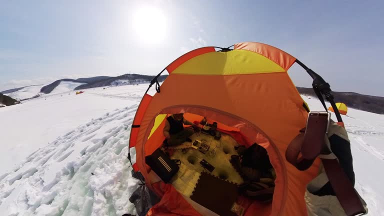 Ice fishing in Japan view from above frozen lake down into fishing hole underwater