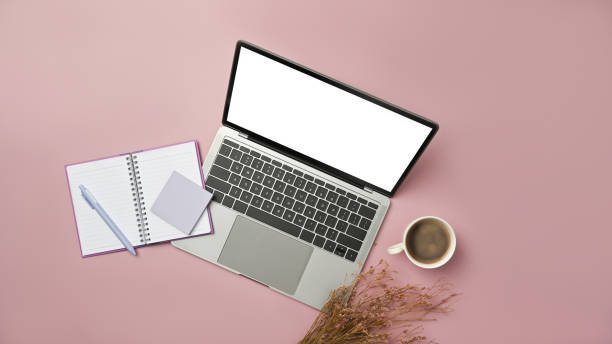istock Above view of laptop computer, notepad and coffee cup on pink background. Blank screen for advertise design. 1468428498