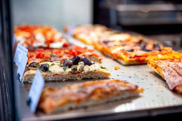 istock Various types and tastes of rectangle-shaped pizza in take out showcase 1468428701