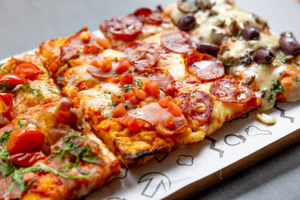 istock Close-up on tray of various types of pizza rectangle-shaped 1468428824