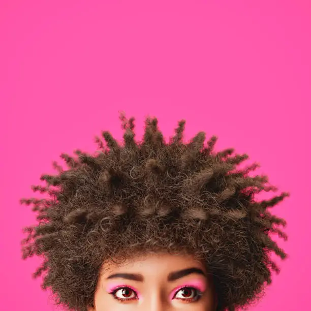 3D rendering of crop unrecognizable ethnic female millennial with dark Afro hair and bright eyeshadow looking away against pink background. 3d character, not real person