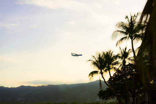 Scenic view of commercial airplane landing on tropical island in Thailand