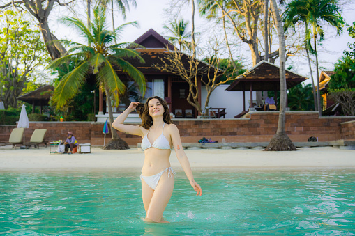 Young Woman in white swimwear swimming in the sea on Ko Samui