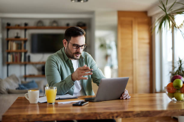 istock Young businessman having a conference call over a computer at home. 1468435203