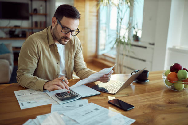 istock Young man working on his financial bills at home. 1468435794