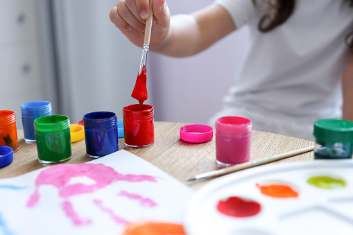 The child holds a brush with paint in his hands. Artistic master class.