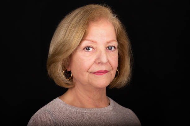 istock Lady in her 70s in a studio headshot over back background 1468438119