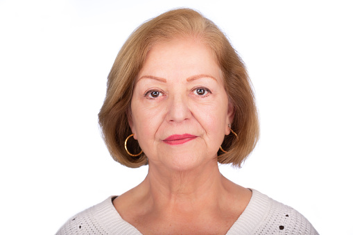 Lady studio headshot over white background. She is serious in a frontal view