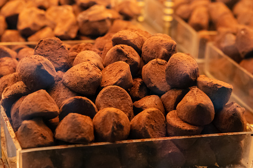 Chocolate truffles covered with cocoa a lot on shop window. Heap of chocolate truffle.