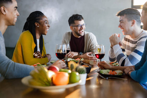istock Cheerful friends enjoying in conversation during dinner at dining table. 1468439502