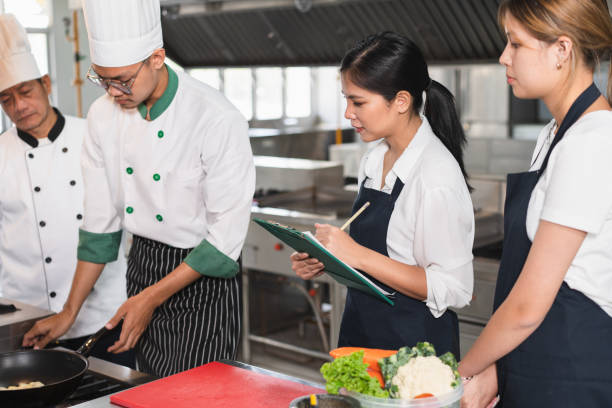 istock Asia woman assistant chef holding clipboard cooking learning with kitchen background 1468444563