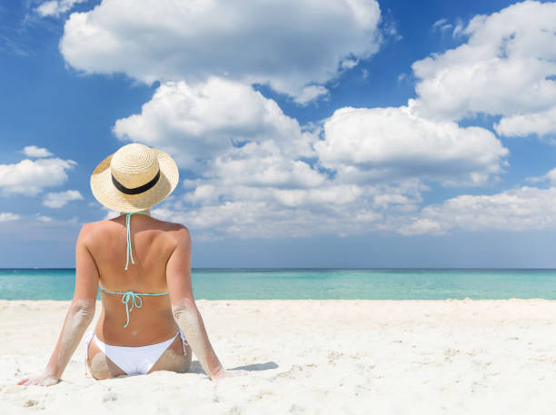 istock Woman sitting on the sea beach 1468446711