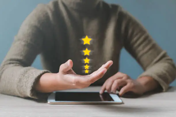 Photo of Gesture hand with golden five star awards. Opened hand of customer giving a five star rating. Satisfaction survey, customer service, Success in business concept.