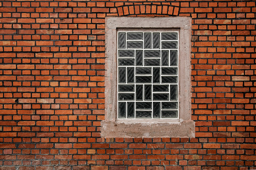 Brick stone wall with glass brick window and
space for text, no people and horizontal format