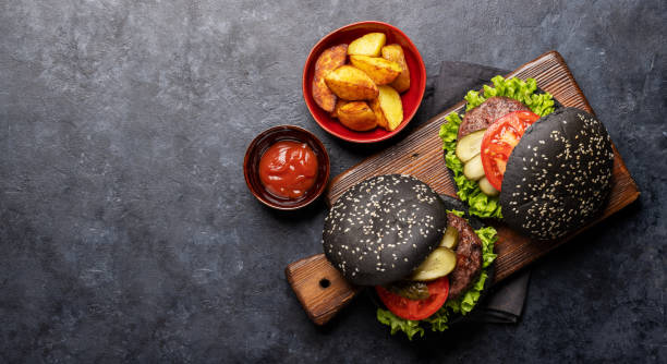 istock Homemade beef burgers with black buns 1468452820