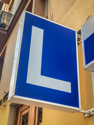 Low angle view of sign in the street with the letter L on it