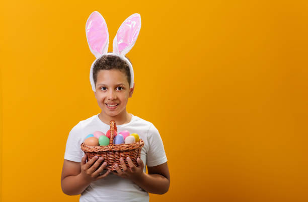 istock A Black boy with bunny ears on his head and a basket full of painted Easter eggs 1468457329