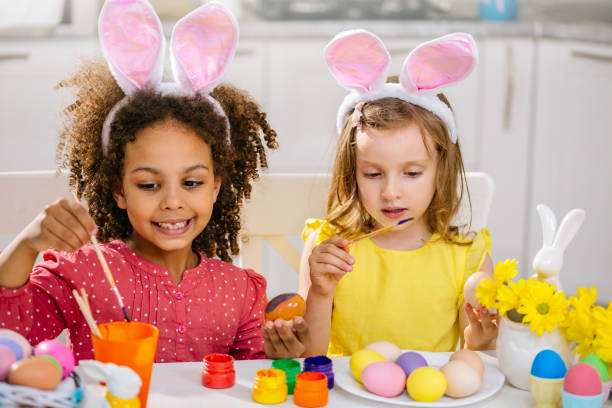 istock Two girls paint Easter eggs for holiday at home 1468457346