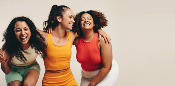 zabawa w odzieży fitness: trzy koleżanki śmieją się radośnie w studiu sportowym - yoga young adult cheerful happiness zdjęcia i obrazy z banku zdjęć