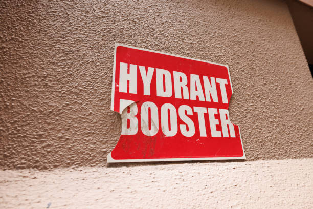 Damaged Hydrant booster sign on a rough wall.