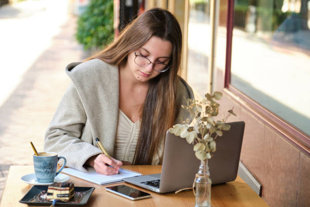 istock Entrepreneur working with a notebook and a laptop in a coffee shop. 1468458107