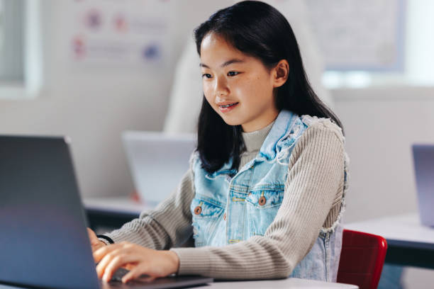 istock Nurturing her tech talent, young girl learns to code on a laptop 1468458338
