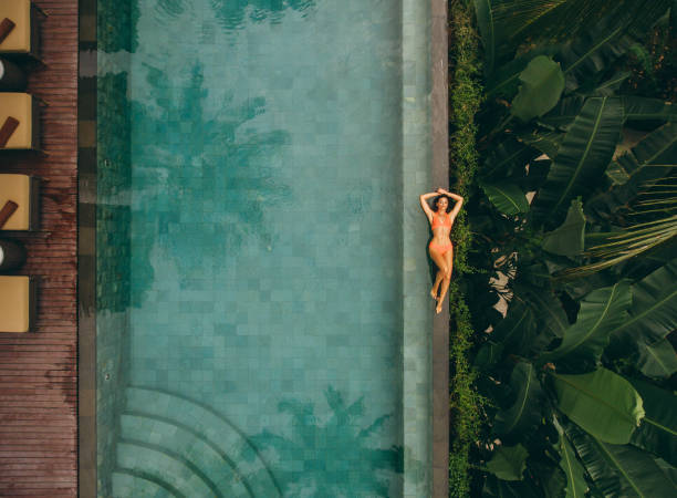 Young woman lying on the poolside stock photo