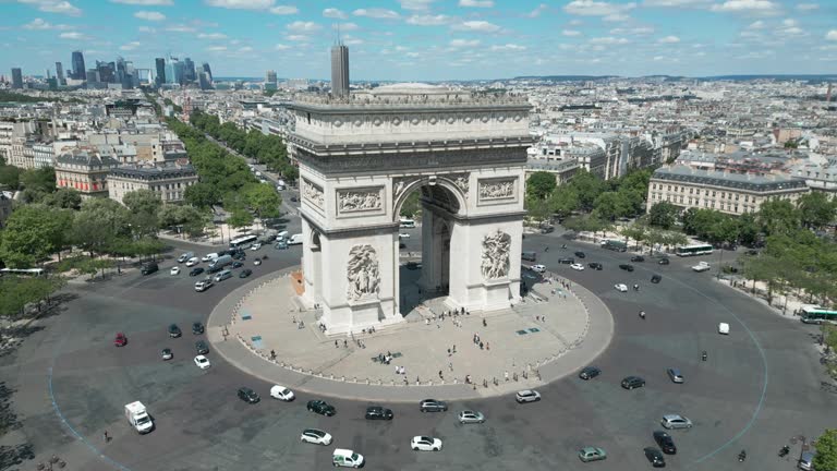 Drone flying around Triumphal arch with Paris cityscape, France. Aerial orbiting