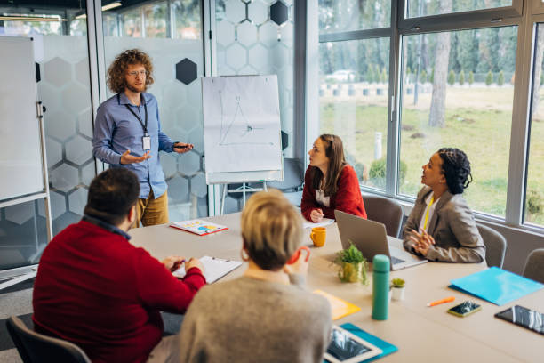 istock Business man talking to his colleagues while giving them a business presentation on whiteboard in the office 1468462448