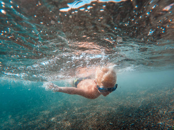 istock Happy Young Kid Swimming And Exploring At The Sea 1468462566