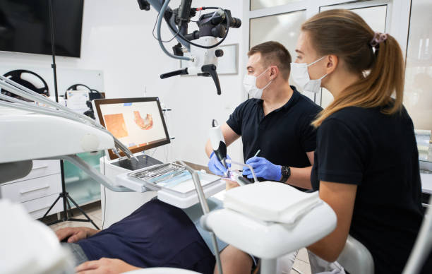 istock Dentist scanning patient's teeth with modern machine for intraoral scanning. 1468463141