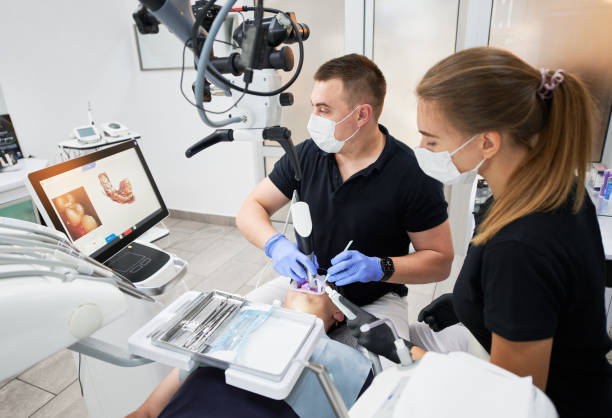 Dentist scanning patient's teeth with modern machine for intraoral scanning.