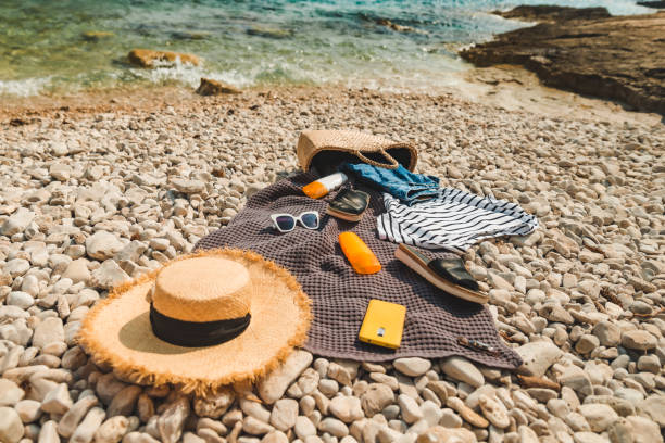 istock overhead view of beach stuff blanket with sun protection cream straw hat with bag 1468465073