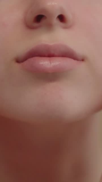 Extreme closeup feminine lips and chin applying anti aging cream