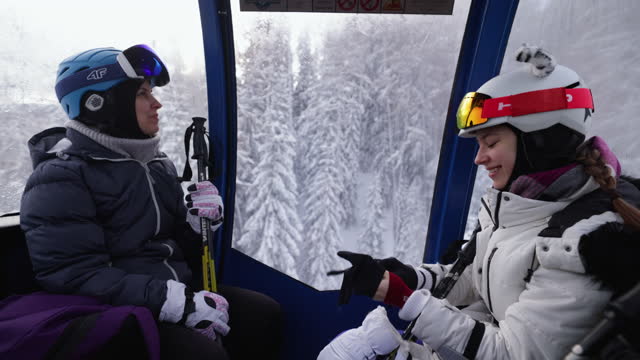 Family enjoying gondola ski lift ride in Alps