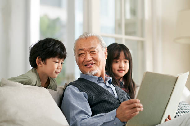 asian grandpa having a good time with grandchildren stock photo