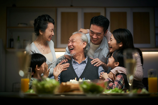 happy three generation asian family celebrating grandpa's birthday at home