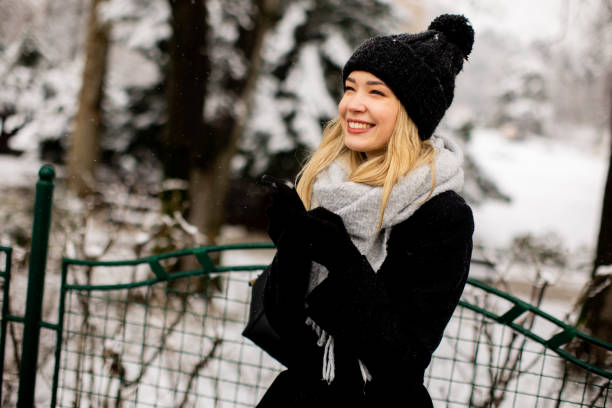 istock Young woman in warm clothes using mobile phone on a winter day 1468467020