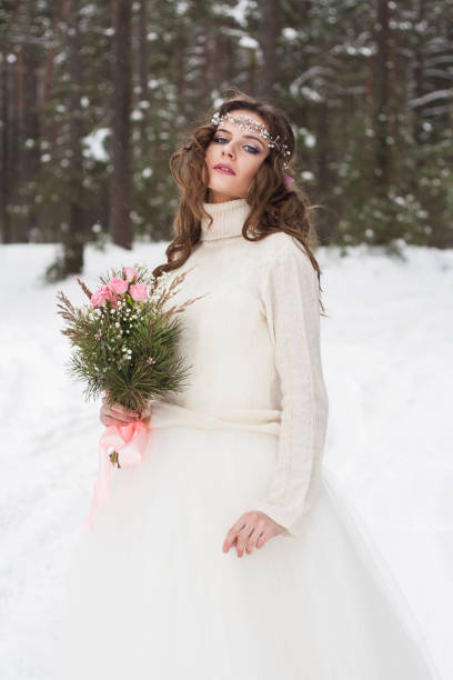 hermosa novia con un vestido blanco con un ramo en un bosque de invierno cubierto de nieve. retrato de la novia en la naturaleza - 13576 fotografías e imágenes de stock